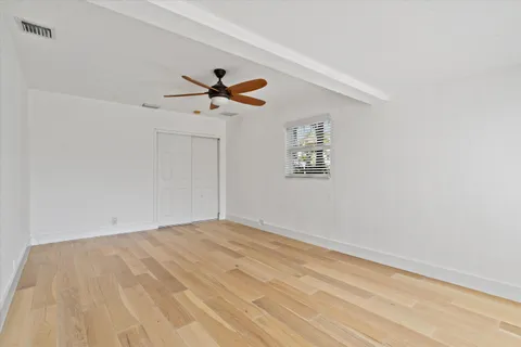 a view of a big room with wooden floor and a ceiling fan
