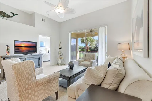 a living room with furniture a flat screen tv and a large window