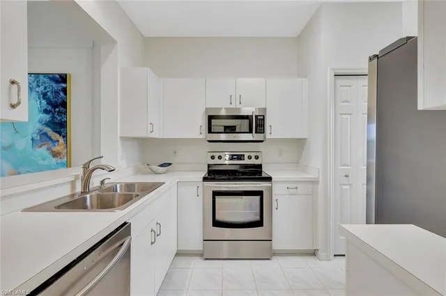 a kitchen with white cabinets and appliances