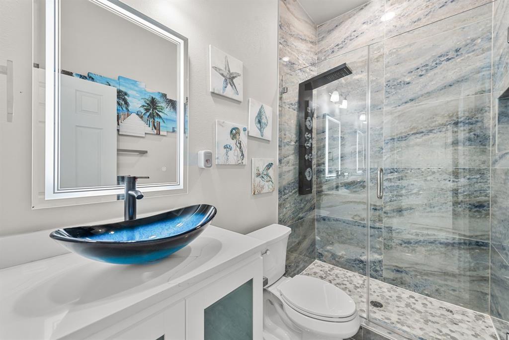 13032 Rudy's Way Streetman, TX 75859 - Photo 26 of 40 Bathroom with blue vessel sink, walk-in shower, and coastal-inspired design details.
