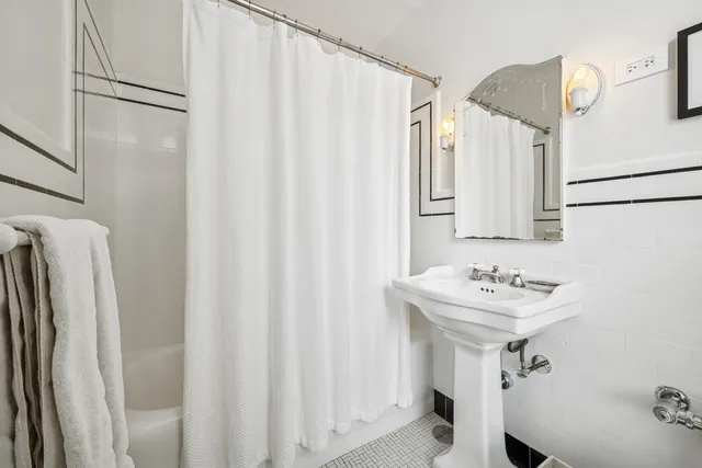 a bathroom with a sink a mirror and a shower curtain