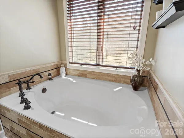 a bathroom with a tub a sink and a window