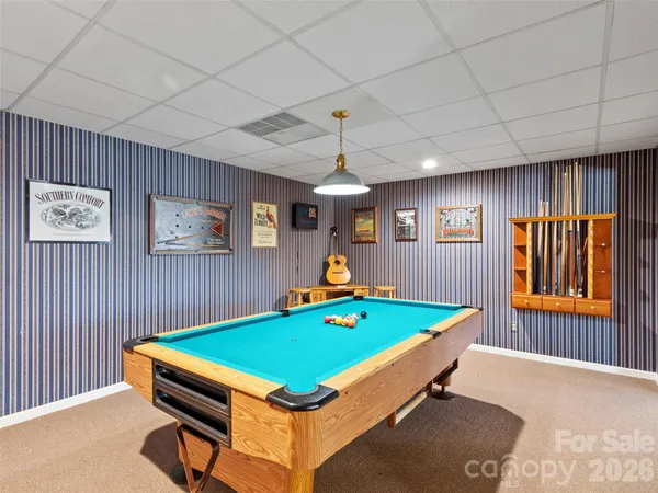 a room with pool table and windows