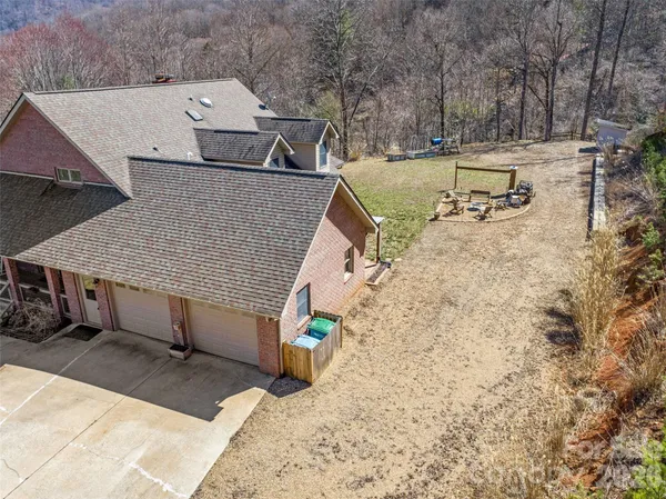 an aerial view of a house with swimming pool and large trees
