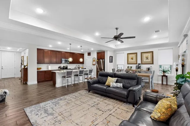 a living room with furniture kitchen view and a chandelier