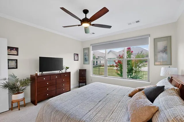a bedroom with a bed a window and a flat screen television