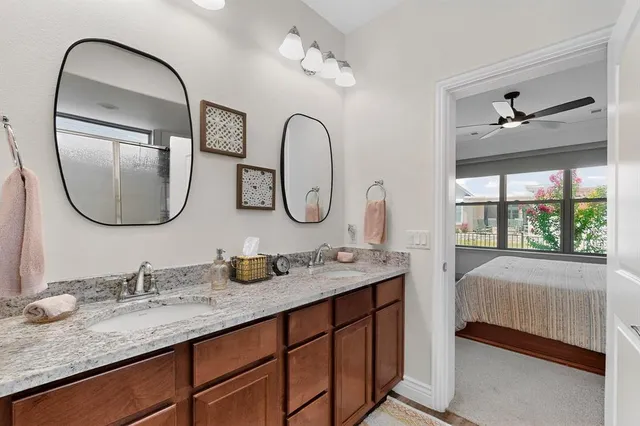 a en suite bathroom with a granite countertop double vanity and a mirror