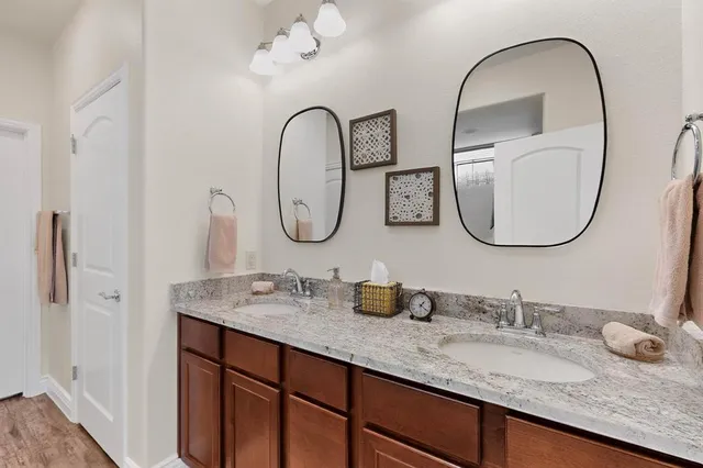 a bathroom with a granite countertop double vanity sinks and a mirror
