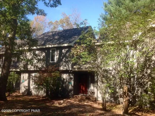 a front view of a house with a tree