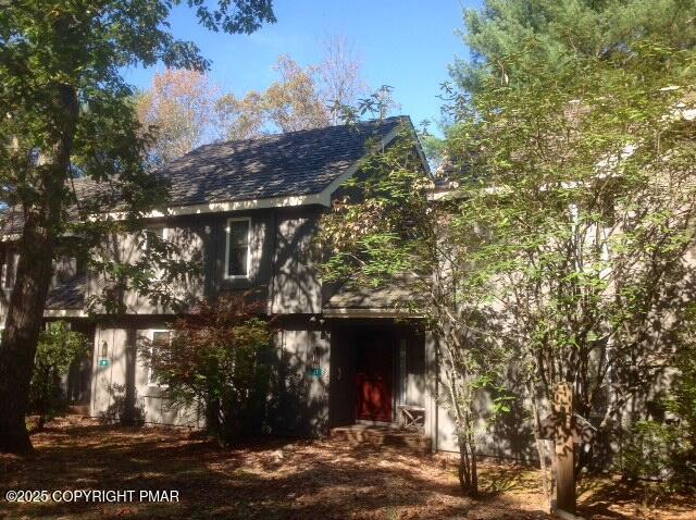a front view of a house with a tree