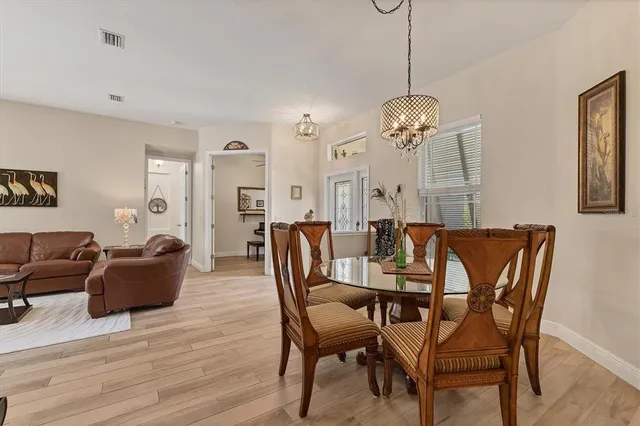 a kitchen with stainless steel appliances granite countertop a table chairs a refrigerator and a stove