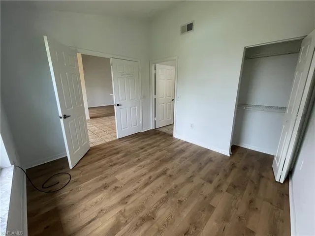an empty room with wooden floor and entrance