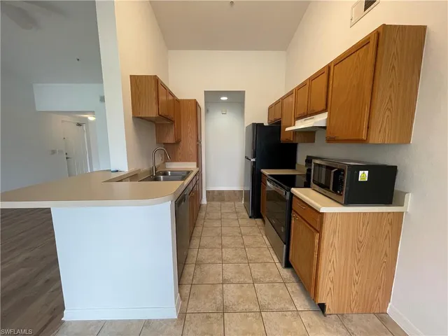 a kitchen with a sink a counter top space cabinets and stainless steel appliances