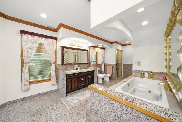 a large bathroom with a tub a sink and a large mirror
