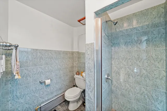 a bathroom with a granite countertop toilet a sink and a shower