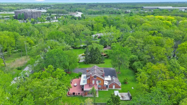 an aerial view of residential houses with outdoor space and trees