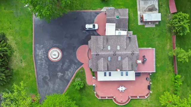 an aerial view of a house with outdoor space and a garden