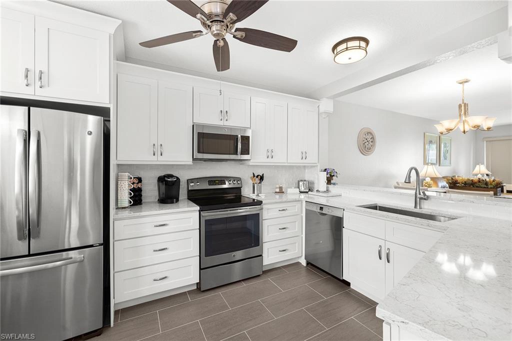 9022 Michael Circle, Unit 3 Naples, FL 34113 - Photo 12 of 25 a kitchen with a sink appliances and cabinets