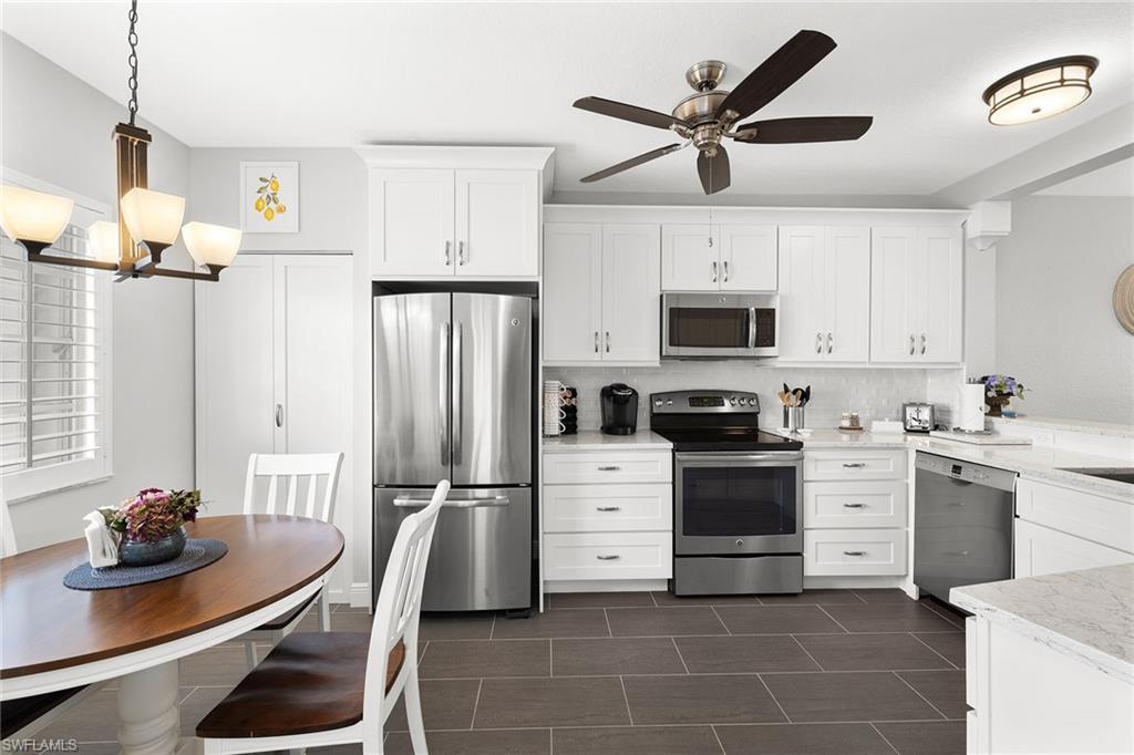 9022 Michael Circle, Unit 3 Naples, FL 34113 - Photo 13 of 25 a kitchen with stainless steel appliances a stove refrigerator sink and cabinets