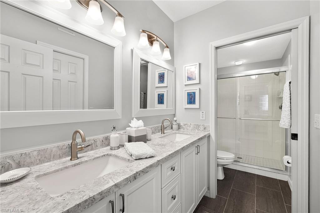 9022 Michael Circle, Unit 3 Naples, FL 34113 - Photo 17 of 25 a bathroom with a granite countertop sink toilet and shower