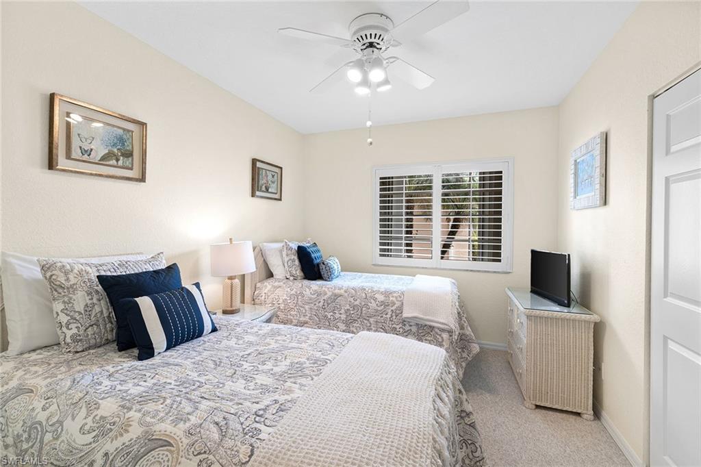 9022 Michael Circle, Unit 3 Naples, FL 34113 - Photo 19 of 25 a bedroom with a bed and a flat screen tv