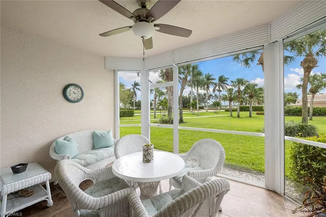 a living room with patio furniture and a large window