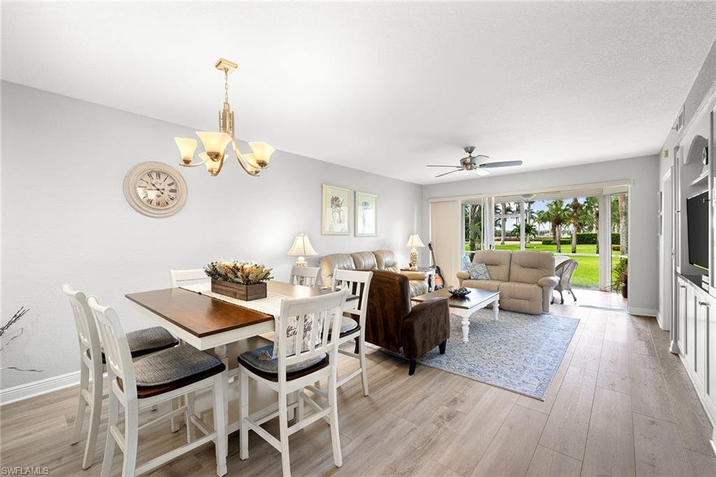 9022 Michael Circle, Unit 3 Naples, FL 34113 - Photo 9 of 25 a view of a dining room and livingroom with furniture wooden floor a chandelier