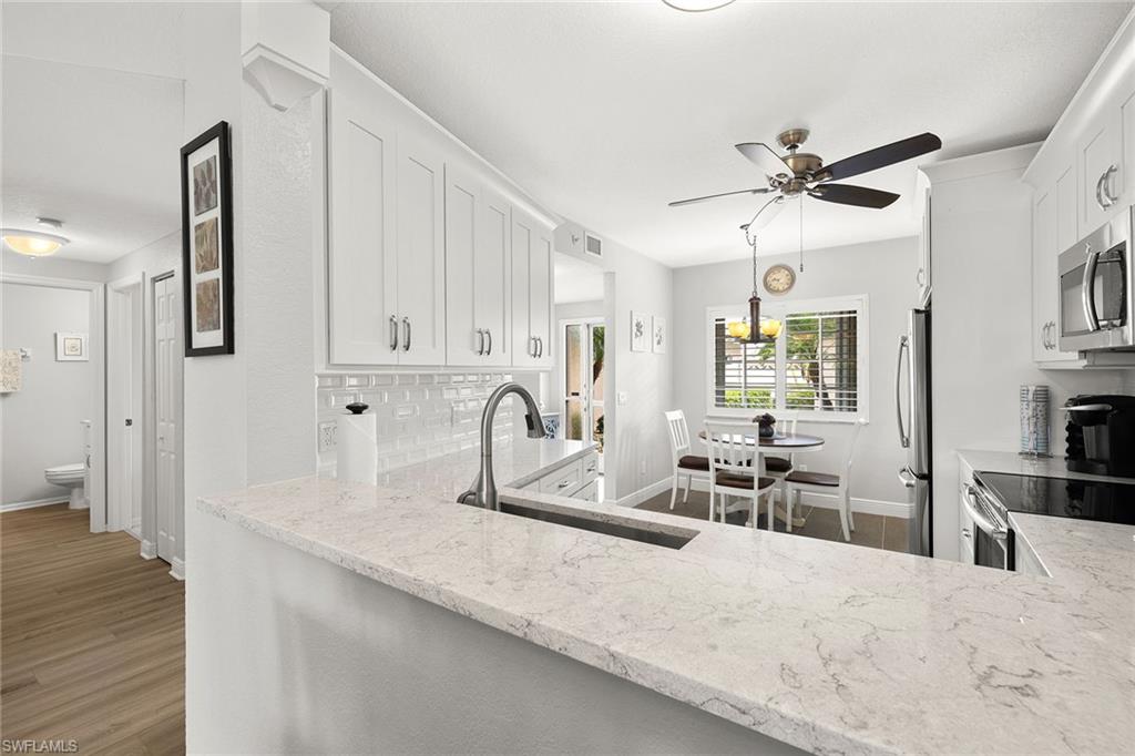 9022 Michael Circle, Unit 3 Naples, FL 34113 - Photo 10 of 25 a kitchen with granite countertop a sink a counter top space appliances and cabinets