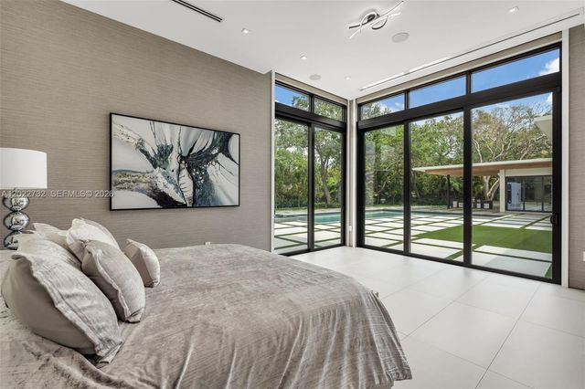 a large bed sitting in a bedroom next to a large window