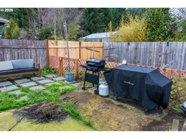 a view of a backyard with wooden fence