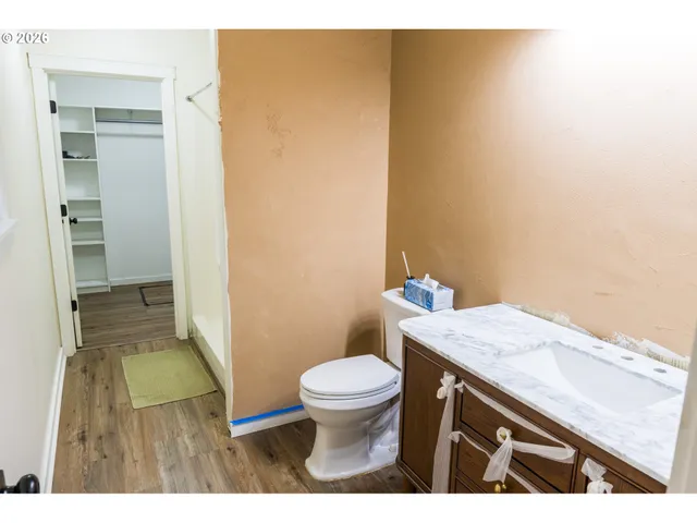a bathroom with a granite countertop sink and a toilet