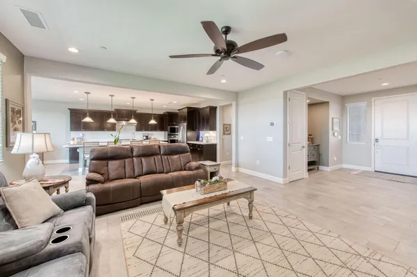 a kitchen with stainless steel appliances kitchen island granite countertop a table chairs and a refrigerator