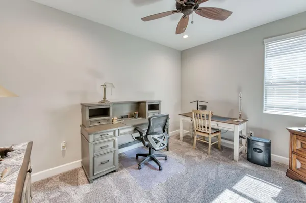 a view of a workspace with furniture and a window