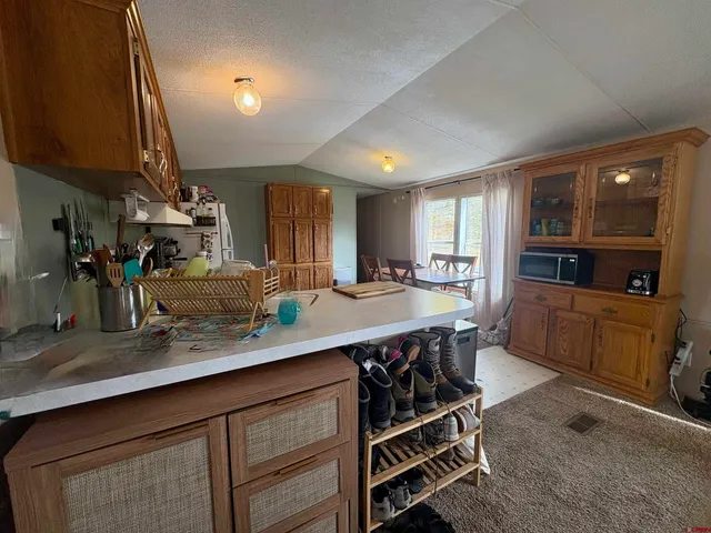 a kitchen with kitchen island granite countertop a sink cabinets and stainless steel appliances