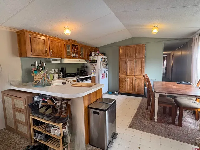a kitchen with stainless steel appliances kitchen island granite countertop a stove a sink and a refrigerator