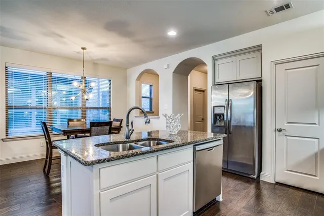 a kitchen with stainless steel appliances granite countertop a sink and a refrigerator