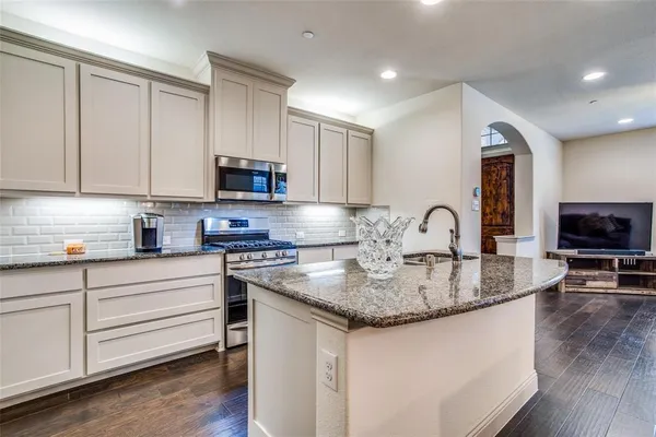 a kitchen with granite countertop a stove and a sink