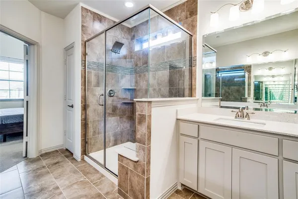a bathroom with a double vanity sink mirror and shower