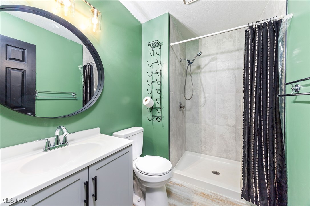 2840 Wadsworth Road Barberton, OH 44203 - Photo 14 of 32 Bathroom featuring a shower stall, vanity, and wood finished floors