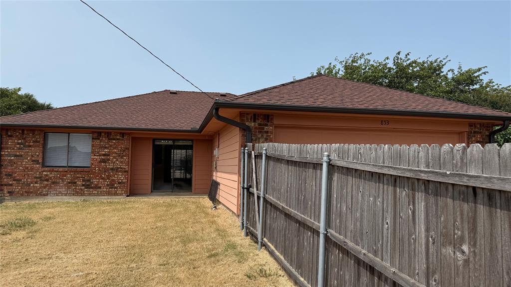 853 West Wintergreen Road Lancaster, TX 75134 - Photo 18 of 20 Brick exterior with a brown shingle roof, integrated garage, and a sliding glass door
