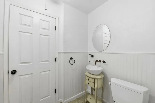 a bathroom with a toilet a sink and mirror