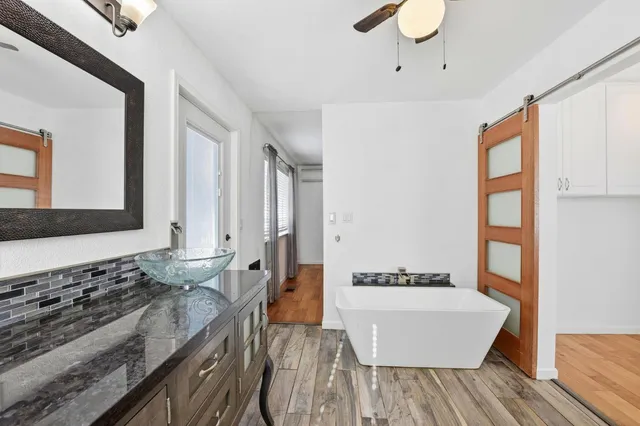 a spacious bathroom with a granite countertop sink and a bathtub