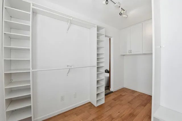 a view of walk in closet with empty racks