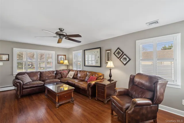 a living room with furniture ceiling fan and a window