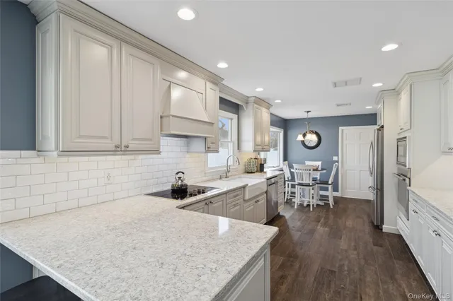 a kitchen with stainless steel appliances granite countertop a sink refrigerator and cabinets