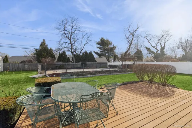 a view of a backyard with table and chairs potted plants and wooden fence