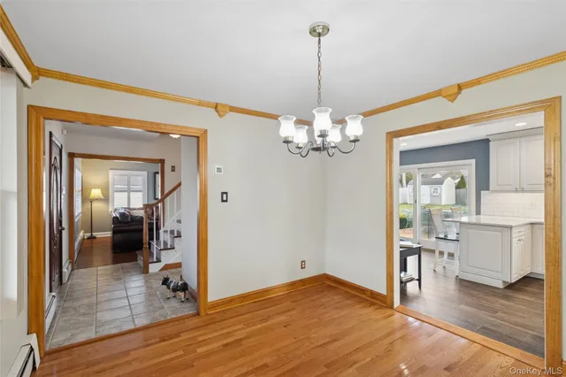 a view of a livingroom with wooden floor and kitchen space