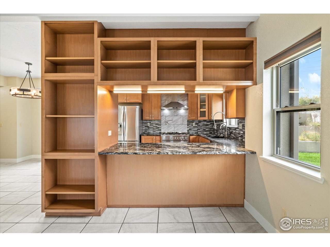 403 Double Tree Drive Greeley, CO 80634 - Photo 11 of 49 a room with stainless steel appliances kitchen island granite countertop a refrigerator and cabinets