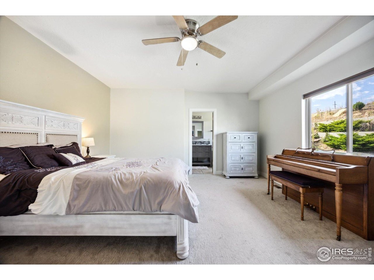 403 Double Tree Drive Greeley, CO 80634 - Photo 15 of 49 a bedroom with a bed and a chandelier