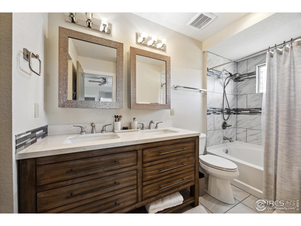 403 Double Tree Drive Greeley, CO 80634 - Photo 27 of 49 a bathroom with a granite countertop sink toilet a large mirror and shower